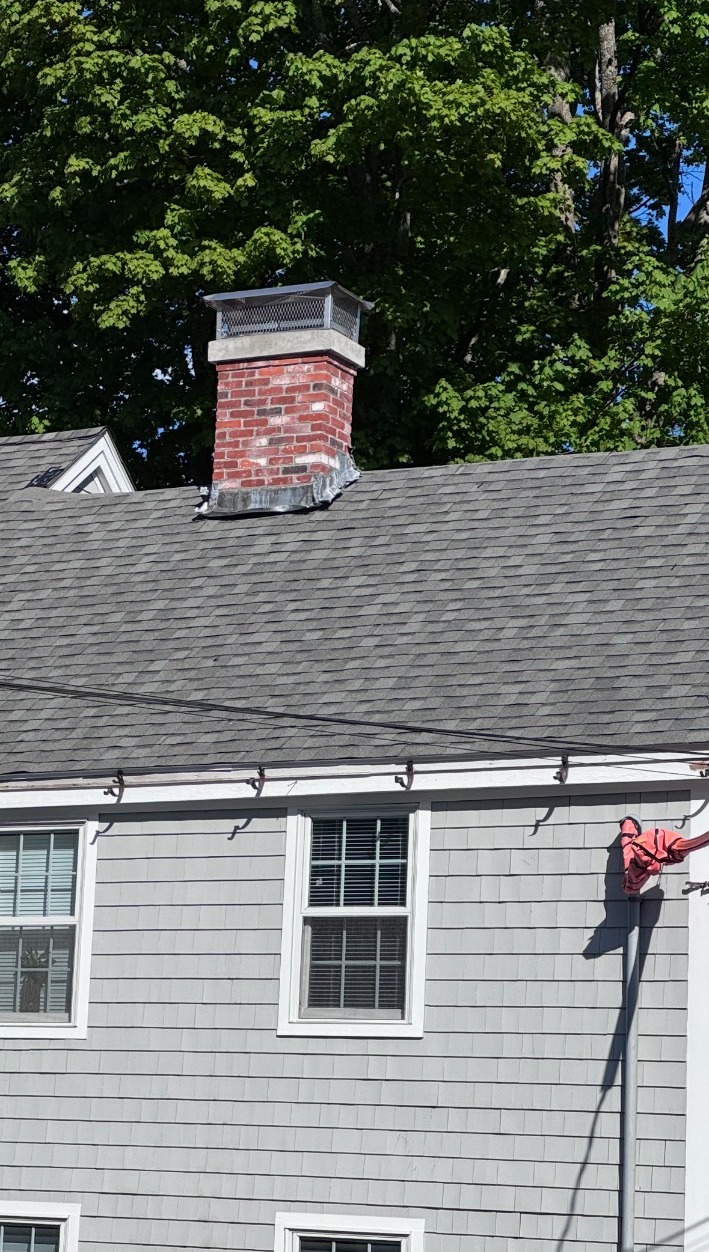 Completed shingle roof with restored brick chimney