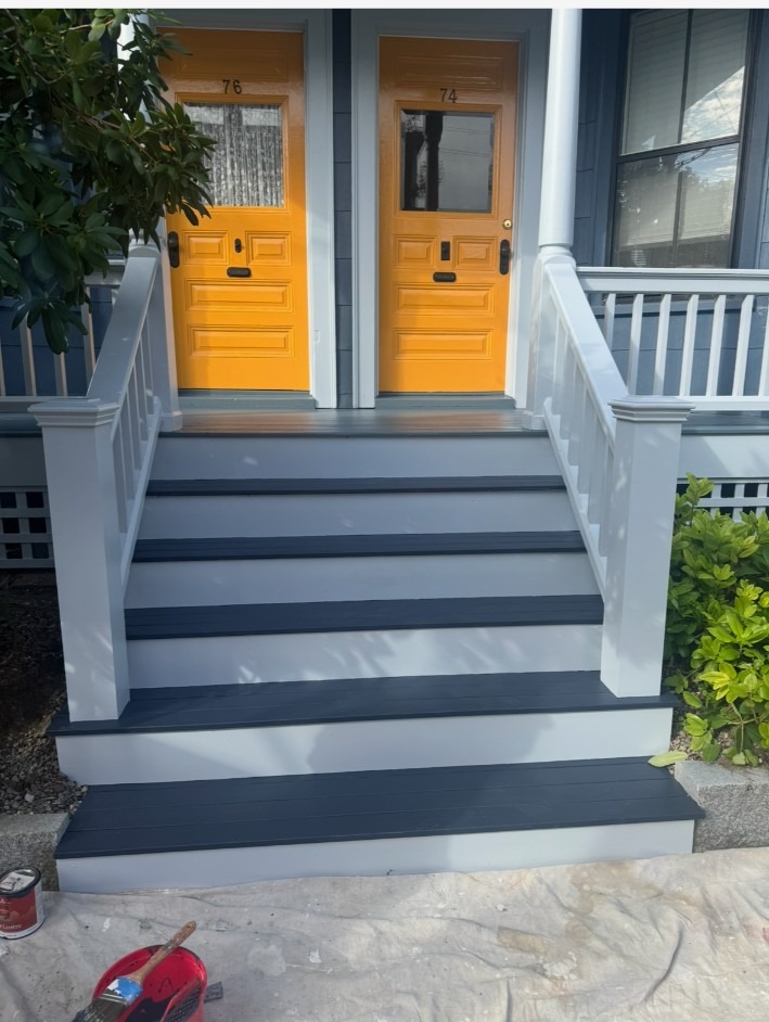 Freshly painted front porch steps with yellow doors